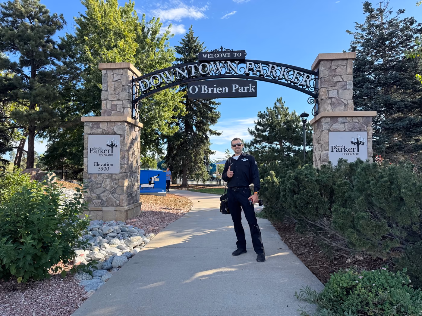 ColdPros technician standing under the Welcome to Downtown Parker arch at O’Brien Park in Parker, Colorado