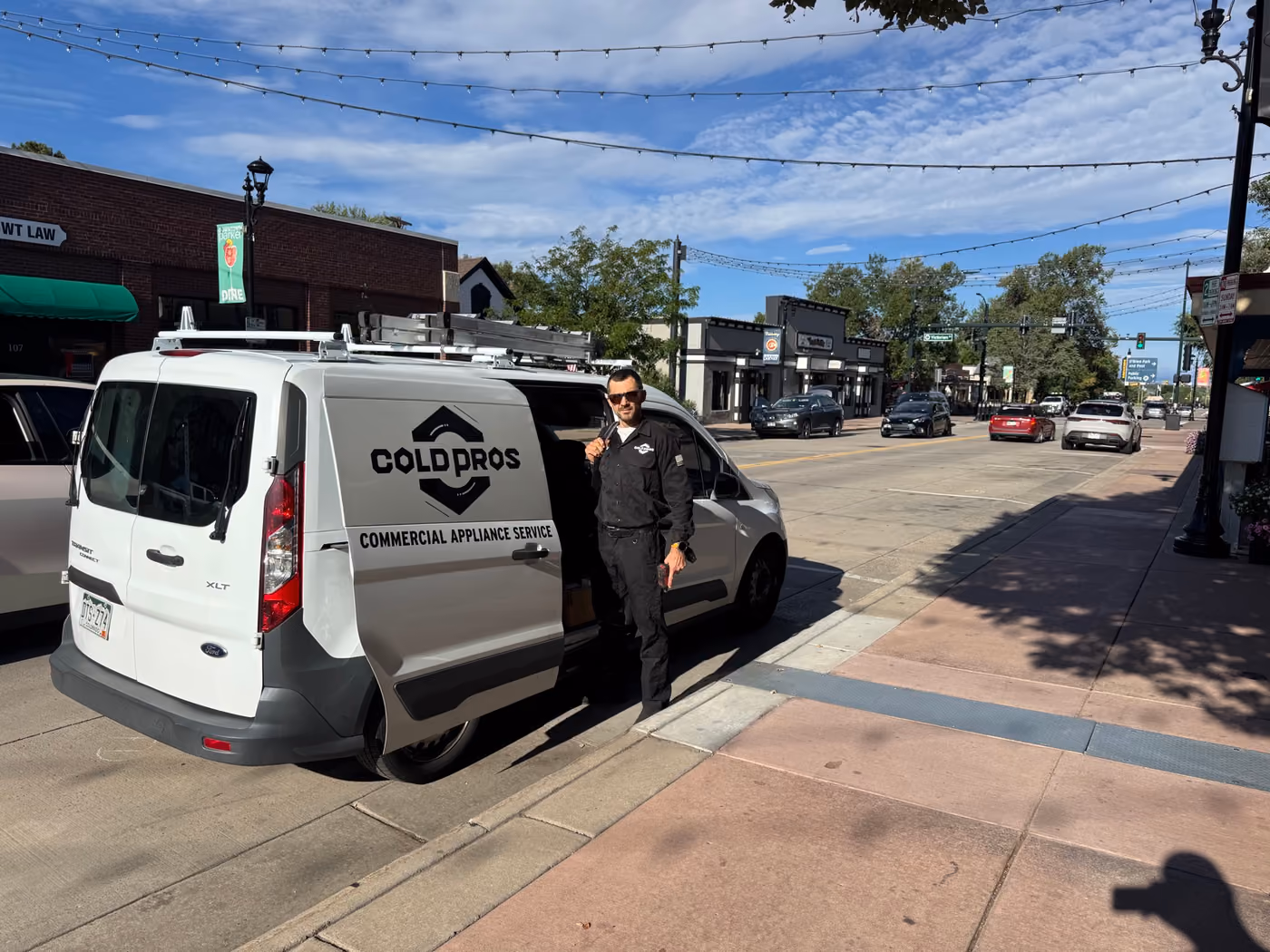 ColdPros Commercial Appliance Service van parked on Mainstreet in downtown Parker, with a technician at the side door